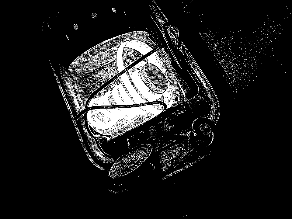 Atkinson dithering. Un antigua lámpara de queroseno, reconvertida en eléctrica gracias a una fina tira led envuelta en un carrete de hilo, destaca en la oscuridad.